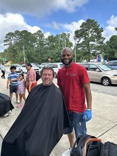 Councilor Ben McDonald gets a haircut at the Arts and Education Festival