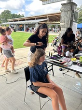 female student getting braids in her hair at the Arts and Education Festival