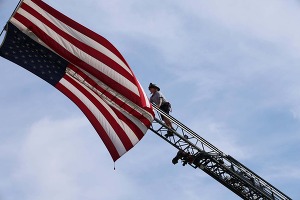Knightdale Fire Fighter Hoists Flag at Fourth on First Avenue Celebration