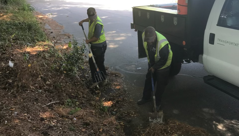 staff cleaning storm drain