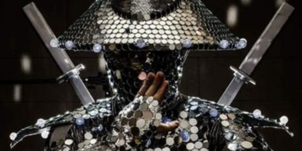 Costumed actor as silver-coin covered Asian warrior