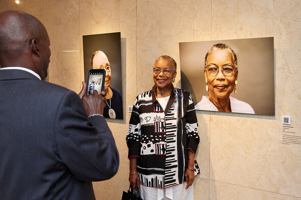 Brenda Davis standing in front of her portrait at the Voices of Oberlin Exhibition 