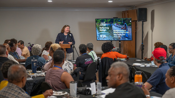 Reflecting Raleigh - An image of a speaker in front of an audience at a community conversation