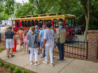 A group of people wait to board the trolley.
