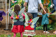 Two girls wear fairy wings.