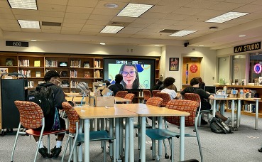 picture of tables with students and projected screen