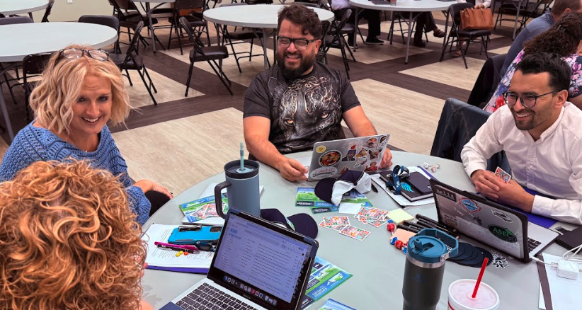 Photo of teachers sitting at a table laughing