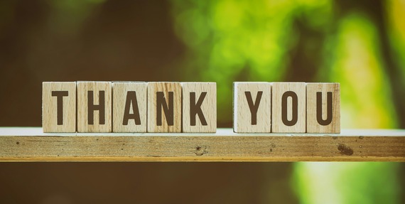 wooden blocks sitting on a block of wood that spells out "thank you"