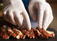 Gloved hands preparing food