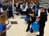 Group of job seekers in a large space with vendor tables