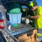 A contractor removes hazardous materials from a resident's vehicle at Union County's 2023 Household Hazardous Waste Event. 