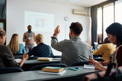 Classroom of adults with hand raised