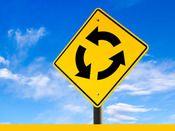 Roundabout Road Sign with blue skies in the background