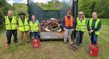 Group of people in safety vests piling up debris