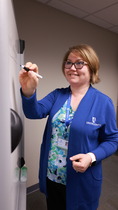 Megan Hinkle wearing Union County cardigan while writing on a dry erase board.