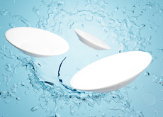 Clean white dishes with water splashing 