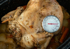 Roast chicken with a food thermometer to check the temperature 