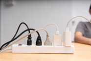 electrical power strip on a desk with multiple cords plugged in