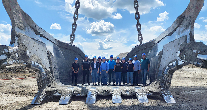 Dragline bucket with Commerce staff and others standing in it