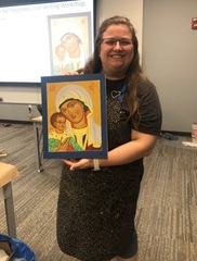 a female artist holding a framed painting she made