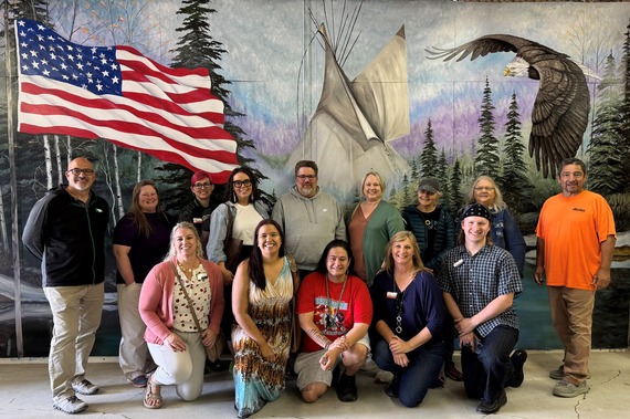NDCA Board and staff visiting the Rolette County Historical Society Museum, standing in front of a mural