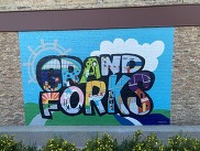 The words GRAND FORKS painted on a wall outside in bright colors