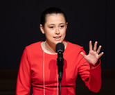 2026 ND Poetry Out Loud champion Aspen Geist of Wyndmere, ND, reciting poetry into a microphone on stage