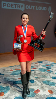 high school student Aspen Geist, wearing a short red dress, holding her 2026 ND State POL champion awards on stage