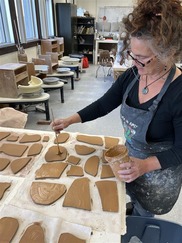 Region 8 artist Ryah Christensen working on clay tiles