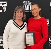 North Dakota 2026 POL champion Aspen Geist standing with her teacher Jennifer Manstrom in front of a POL backdrop
