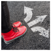 person wearing red sneakers standing behind directional arrows on the ground