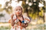 photo of young child blowing bubbles