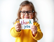child holding thank you sign