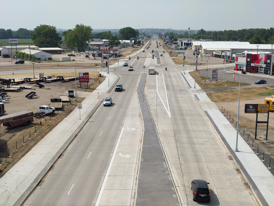 West-facing aerial view of completed road construction on Memorial Highway's east end, showing the finished roadway, sidewalks, and signals.
