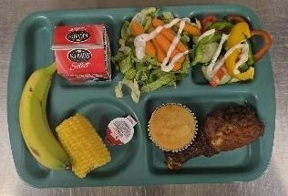 Lunch tray with healthy food featuring corn on the cob.
