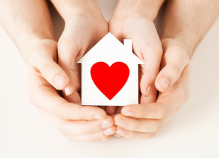 stacked hands holding house with heart