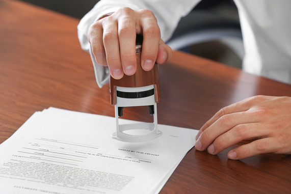Person placing a notary stamp on notarized document