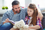 man listening to girl read a book out loud