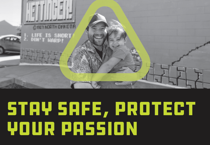 Black and white photo of man smiling holding child with green triangle around them