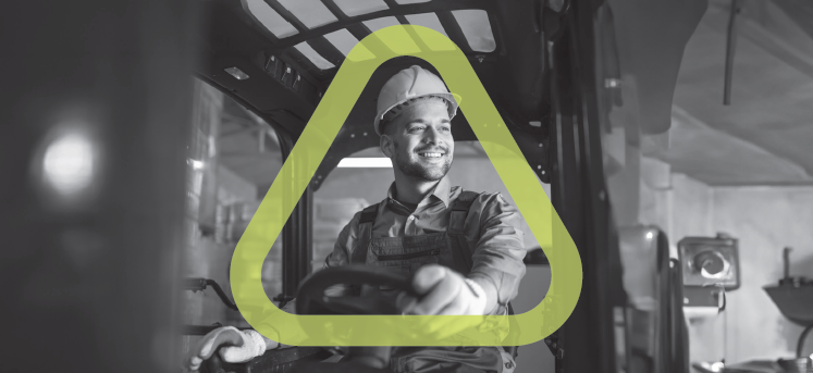 Black and white photo of man smiling while driving a forklift with the Get Home Safe triangle around him