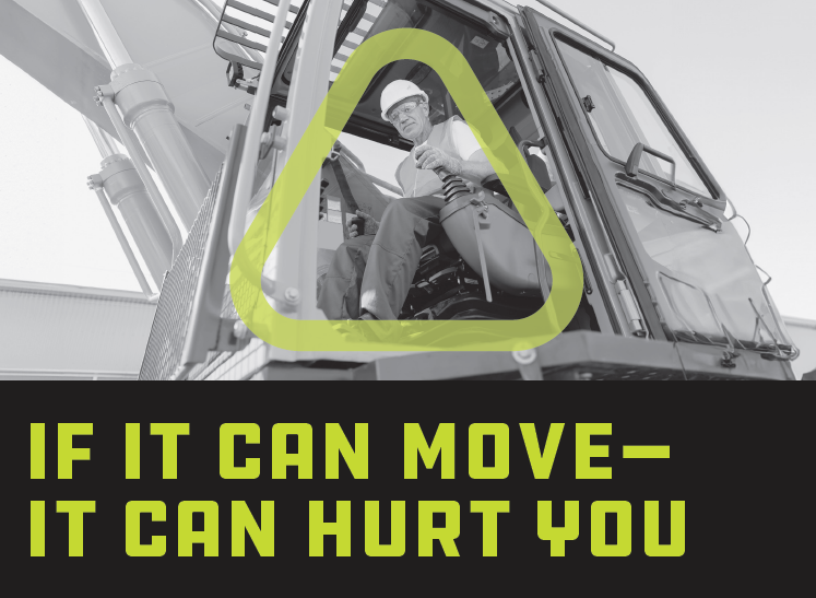 Black and white photo of man smiling and looking out from the cab of a piece of heavy equipment
