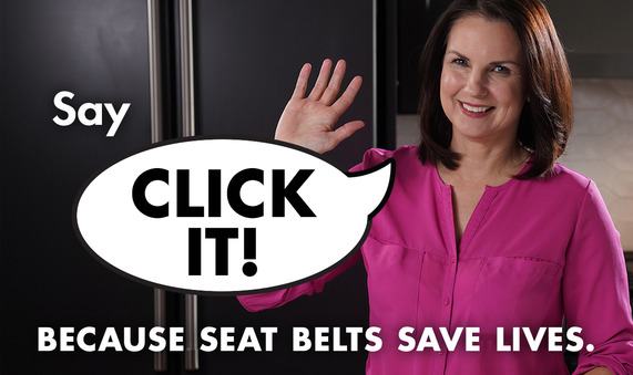Woman wearing pink shirt waves at camera with the words Click It in the background.