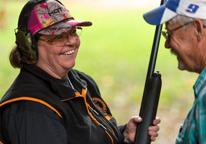 A woman smiling during a beginning shotgun BOW class