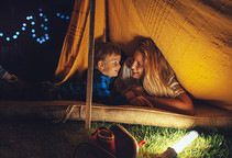 Mother and son camping in backyard