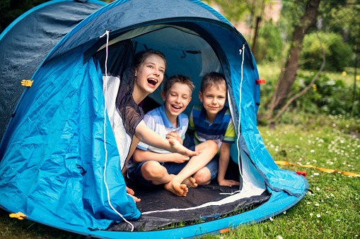 Kids playing in a backyard tent