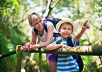 Boy pointing on a wooded trail alongside his mom