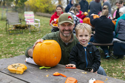 Father and son carving a pumpkin at Ponca State Park's Hallowfest.
