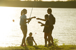 A family fishing together at sunset