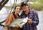 A young couple holding a fish
