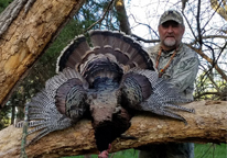 Daryl Bauer posing with harvested tom